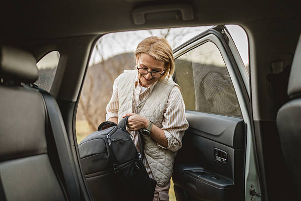A backpack being loaded into the trunk of a taxi